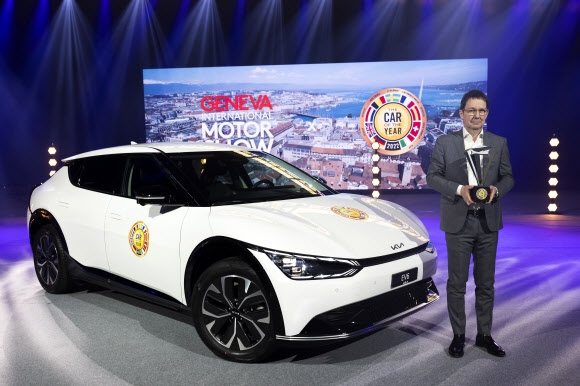 ‘2022 유럽 올해의 차’ 심사위원장인 프랑크 얀센이 28일(현지시간) 스위스 제네바에서 열린 온라인 시상식에서 ‘올해의 차’로 선정된 기아의 전용 전기차 EV6 앞에서 트로피를 들어 보이고 있다. 국내외 자동차 상을 휩쓸고 있는 EV6는 지난해 8월 출시 이후 3만 2000여대(내수 1만 1000대, 수출 2만 1000대)가 팔리며 예상보다 빠른 성장세를 보이고 있다. 제네바 EPA 연합뉴스