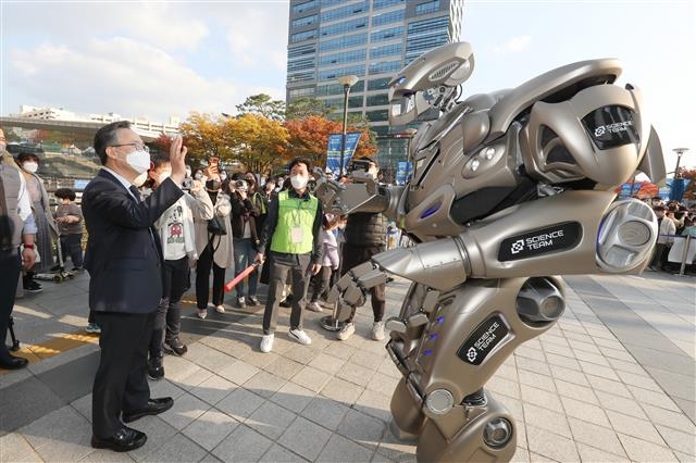 지난해 11월 열린 제3회 금천과학페스티벌에서 유성훈 금천구청장이 대형 로봇 타이탄과 손을 흔들며 인사하고 있다. 금천구청 제공