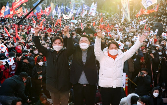 윤석열(가운데) 국민의힘 대선후보가 지난 5일 서울 광진구 어린이대공원 후문 광장에서 열린 유세에서 이준석(왼쪽) 대표, 지난 3일 단일화에 전격 합의한 안철수 국민의당 대표와 함께 공동 유세에 나서 손을 잡고 만세하고 있다. 정연호 기자