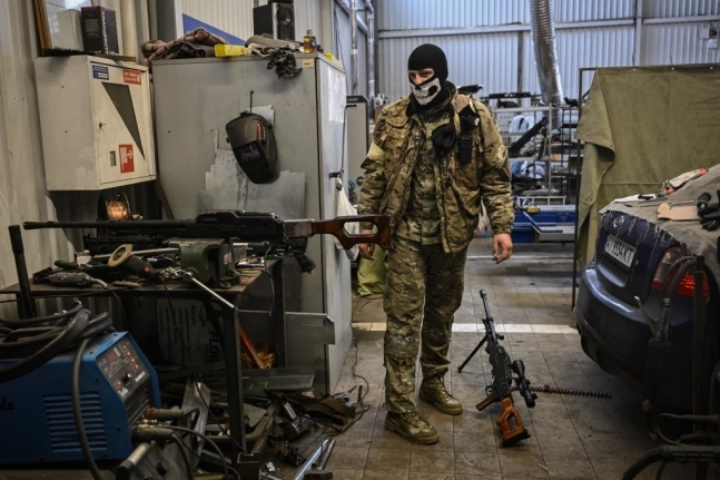 6일(현지시간) 우크라이나 수도 크이우(키예프)의 자동차 수리점에서 한 자원봉사자가 러시아군으로부터 뺏은 무기를 수리하고 있다. AFP 연합뉴스 