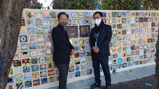 서귀중앙여자중학교 정문 담장벽화를 완성한 기념으로 양덕부 교장과 송수일(왼쪽) 교사가 포즈를 취하고 있다.  서귀중앙여자중학교 제공 