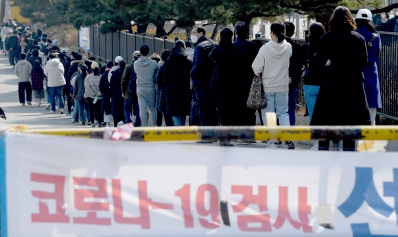 코로나 확진자가 34만명으로 폭증한 가운데 9일 서울 송파구 잠실 주 경기장 앞에 마련된 선별진료소를 찾은 시민들이 줄을서서 코로나19검사를 받고 있다. 2022.3.9 박지환기자