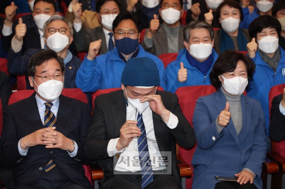 송영길 더불어민주당 대표가 제20대 대선 본투표일인 9일 서울 여의도 국회 의원회관 대회의실에 마련된 개표 상황실에서 지상파 방송 3사와 JTBC 출구조사 결과를 보며 눈물을 닦고 있다. 왼쪽부터 이낙연 총괄선대위원장, 송 대표, 추미애 명예선대위원장. 정연호 기자