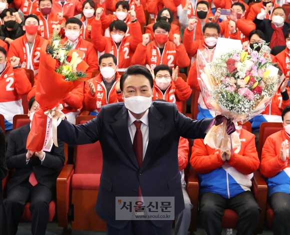 윤석열 국민의힘 대선 후보가 10일 새벽 서울 여의도 국회 도서관에 마련된 개표상황실을 찾아 당선 축하 꽃다발을 받아들고 있다. 2022.3.10 정연호 기자