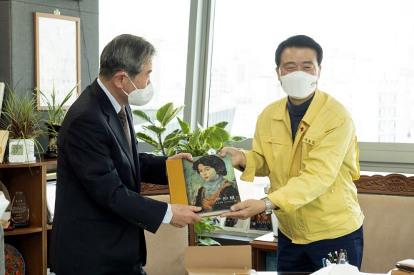 한국 근대 서양화가 윤중식 작가의 아들 윤대경(왼쪽)씨가 윤 작가의 화집을 이승로 서울 성북구청장에게 전달하고 있다. 성북구 제공
