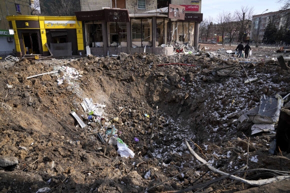 13일(현지시간) 러시아군에 포위된 채 집중 공격을 받고 있는 우크라이나 남부 항구도시 마리우폴의 한 거리에 폭발로 인한 거대한 구덩이가 파여 있다. 2022.3.15 마리우폴 AP 연합뉴스