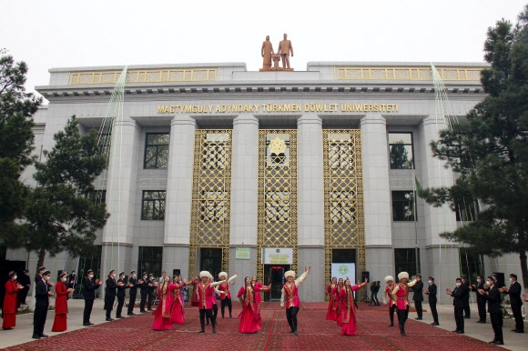 투르크메니스탄 대통령 선거일인 지난 12일(현지시간) 투표소 중 한 곳으로 지정된 수도 아시가바트 소재 국립 막툼굴리대학교의 한 건물 앞에서 전통복장을 한 예술가들이 춤을 추고 있다. 아시가바트 AP 연합뉴스