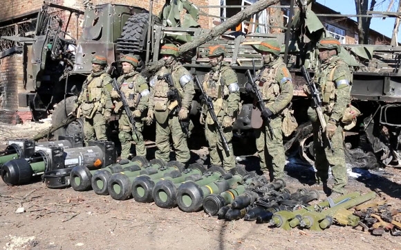 15일(현지시간) 우크라이나 수도권 키이우 지역에서 러시아 군인들이 노획한 서방 제공 무기들을 전시해 놓고 그 뒤에 도열해 있다. 러시아 국방부 공보실 제공 영상 캡처·연합뉴스