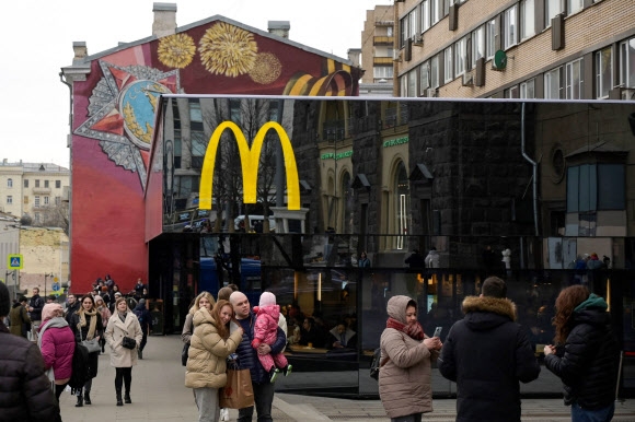 지난 13일(현지시간) 러시아 모스크바 중심부에 위치한 푸시킨 광장의 한 맥도날드 앞에서 사람들이 사진을 찍고 있다. 지난달 24일 시작된 러시아군의 우크라이나 침공 이후 맥도날드를 비롯해 수많은 글로벌 기업들이 러시아 사업 철수를 이어가고 있다. 모스크바 AFP 연합뉴스