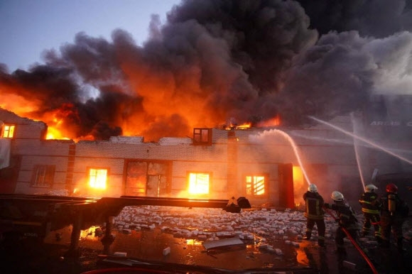 17일(현지시간) 우크라이나 수도 키이우(키예프)에서 소방관들이 러시아군의 폭격을 받은 건물의 불을 끄고 있다. 로이터 연합뉴스