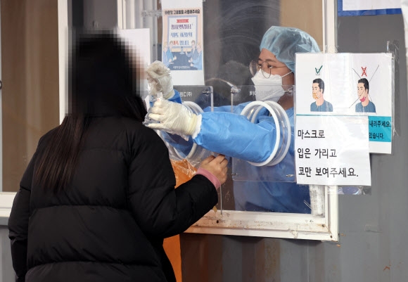 18일 서울역 광장에 마련된 코로나19 임시 선별검사소에서 의료진이 검체를 채취하고 있다. 2022.3.18 연합뉴스