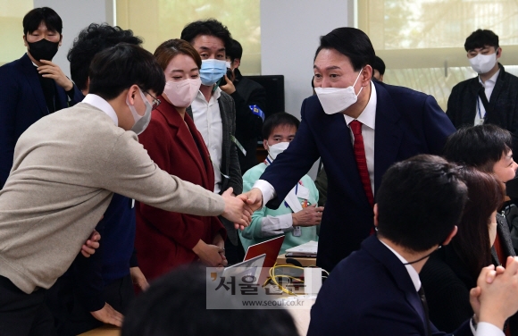 윤석열 대통령 당선인이 20일 서울 종로구 한국금융연수원 별관에 마련된 대통령직인수위원회 기자회견장에서 기자들과 악수하고 있다. 정연호 기자