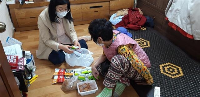 서울 마포구 우리동네돌봄단원(왼쪽)이 지난해 홀몸 어르신을 방문해 안부를 확인하고 있다. 마포구 제공