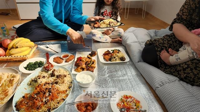 무함마드 나위드씨가 경기 남양주에 있는 자택에서 지난 12일 점심식사 도중 음식을 덜어 아내에게 건네주는 모습. 손지민 기자