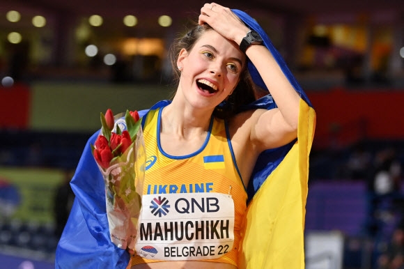 우크라이나의 야로슬라바 마후치크가 19일(한국시간) 세계실내육상선수권대회 여자 높이뛰기에서 금메달을 딴 후 자국 국기로 어깨를 감싼 채 기뻐하고 있다. 자그레브 AFP 연합뉴스