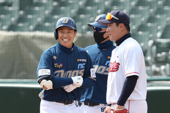 손아섭(왼쪽·NC)이 21일 부산 사직구장에서 열린 롯데전에서 시범경기 첫 안타를 신고한 뒤 1루에서 웃고 있다. 롯데 제공