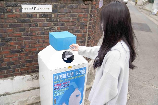 서울 구로구의 한 주민이 개봉1동 단독주택가에 설치된 투명 페트병 수거함에 페트병을 버리고 있다. 구로구 제공