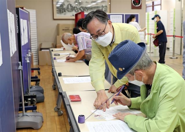 지난해 9월 유성훈 금천구청장이 독산4동 주민센터에서 어르신에게 국민지원금 신청서 작성법을 알려 주고 있다. 금천구청 제공