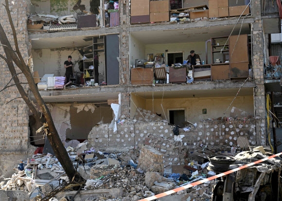 Um prédio de apartamentos de cinco andares em Kiiu, capital ucraniana, foi completamente destruído por bombardeios russos, revelando por dentro.  Os moradores do apartamento voltam para casa no dia 20 (horário local) e coletam os materiais necessários.  Agência de notícias Yonhap Kiiwu AFP