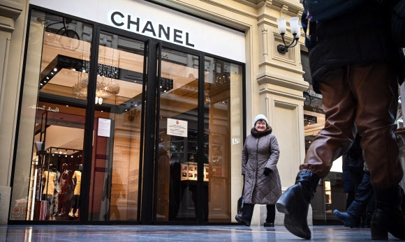 지난 10일(현지시간) 러시아 모스크바의 문 닫은 샤넬 매장 앞을 시민들이 지나고 있다. 우크라이나를 침공한 러시아에 대한 서방의 제재에 발 맞춰 글로벌 기업들의 탈(脫)러시아가 이어지는 가운데 샤넬, 에르메스, 프라다, LVMH 등 유명 패션 브랜드들도 러시아에서의 영업을 중단했다. 모스크바 AFP 연합뉴스
