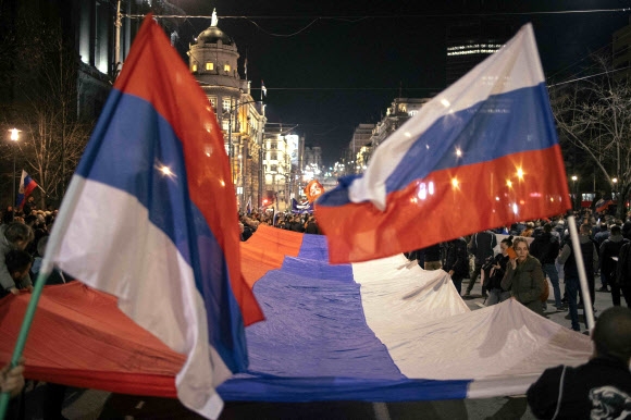 24일(현지시간) 세르비아 베오그라드에서 1000여명의 극단적 민족주의 지지자들이 러시아 국기(오른쪽)와 세르비아 국기(왼쪽)를 들고 러시아의 우크라이나 침공을 지지하는 시위를 벌이고 있다. 세르비아 국기에서 국장 문양을 빼면 두 나라의 국기는 상하 반전된 형태로 국기에 쓰인 3가지 색상은 슬라브주의의 영향을 받은 것으로 전해진다. 베오그라드 AFP 연합뉴스