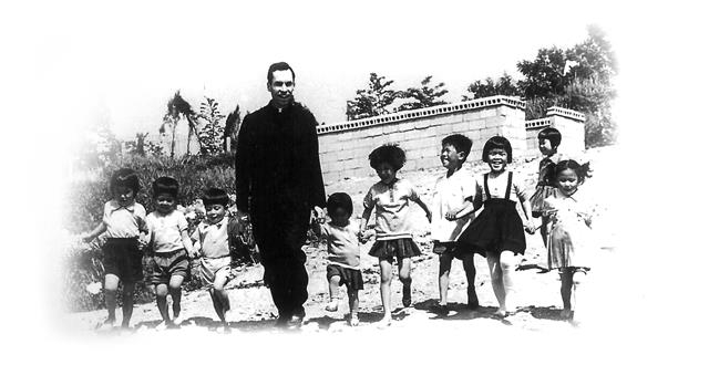 아이들과 함께 손잡고 웃고 있는 소 알로이시오 신부의 생전 모습. 알로이시오 기지 1968 제공
