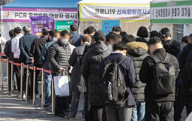 서울 중구 서울역광장에 마련된 코로나19 선별진료소를 찾은 시민들이 검사를 받기 위해 줄을 서 있다. 2022.3.28 뉴스1