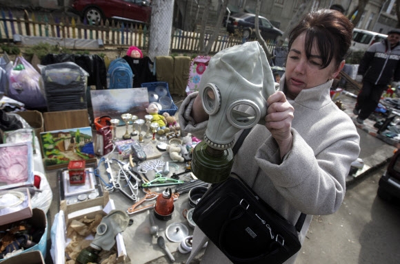 27일(현지시간) 우크라이나 최대 물류거점인 남부 항구도시 오데사의 벼룩시장에서 한 우크라이나 여성이 방독면을 살펴보고 있다. 오데사 EPA 연합뉴스