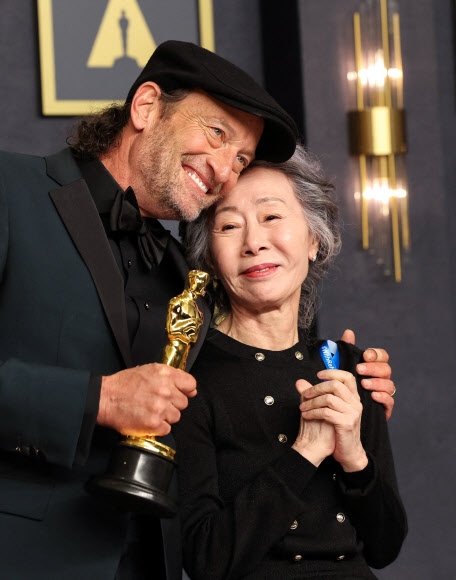 27일(현지시간) 미국 로스앤젤레스에서 열린 제94회 아카데미 시상식에서 남우조연상을 수상한 트로이 코처(왼쪽)가 시상자로 나선 윤여정의 어깨에 손을 얹고 감사를 표하고 있다. 왼쪽 가슴에 유엔난민기구의 난민 캠페인을 지지하는 의미의 파란 리본을 달고 무대에 오른 윤여정은 청각장애를 가진 코처를 배려해 수어로 수상자를 호명해 눈길을 끌었다. 로스앤젤레스 로이터 연합뉴스