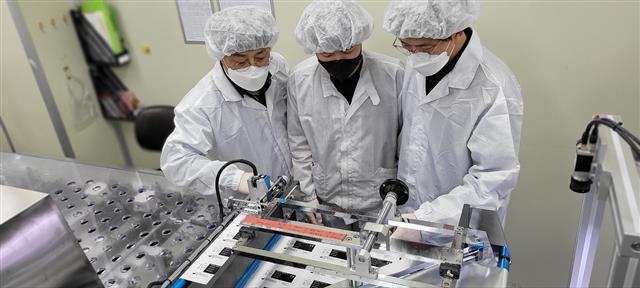 충남 천안에 위치한 자가진단키트 생산업체 ‘젠바디’에서 삼성전자 스마트공장 전문가와 젠바디 직원(가운데)이 검사용 디바이스 포장 라인을 점검하고 있다. 삼성전자 제공