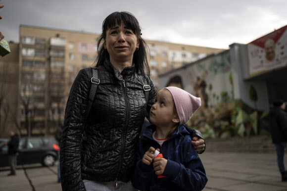 우크라이나 수도 키이우에 대한 러시아군의 공세가 주춤해진 29일(현지시간) 브로바리 지구에 사는 여성 줄리아(34)가 딸 베로니카(6) 옆에서 공포로 지새워야 했던 대피 생활의 어려움을 털어놓고 있다. 키이우 AP 연합뉴스 