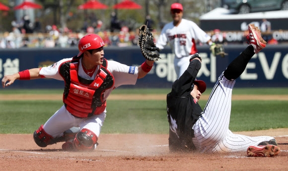 3일 광주 기아챔피언스필드에서 열린 KIA 타이거즈와 LG 트윈스의 경기에서 1회 초 LG 서건창(오른쪽)이 유강남의 적시타 때 3루를 돌아 KIA 포수 김민식의 태그가 있기 전에 홈으로 파고들어 득점을 올리고 있다. 광주 연합뉴스