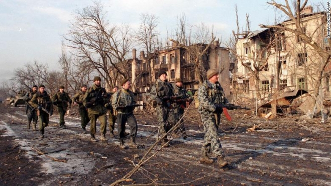 2000년 2월 5일 체첸 그로즈니 거리를 걷는 러시아 군인들이 보인다. 이들 옆으로 폐허가 된 건물 풍경이 자리하고 있다. CNN