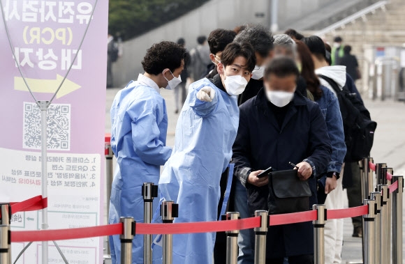 6일 오전 서울역 임시 선별검사소에서 관계자들이 코로나19 검사 대기 중인 시민들에게 관련 안내를 하고 있다.        연합뉴스