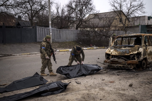 불탄 차 안의 민간인 시신 수습하는 우크라 군인들
