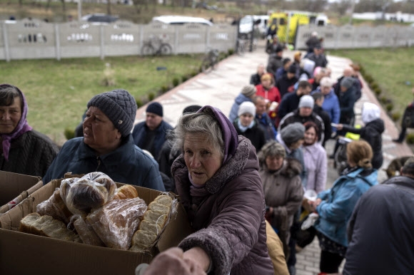 우크라이나 수도 키이우에서 북서쪽으로 약 40㎞ 떨어진 보로댠카 마을의 한 교회에서 주민들이 음식을 배급받고 있다. 2022.4.10 AP 연합뉴스