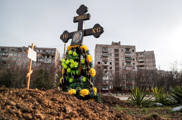 우크라이나 남동부 항구도시 마리우폴의 아파트 근처에 러시아의 침공으로 사망한 주민의 무덤이 보인다. 2022.4.10 로이터 연합뉴스