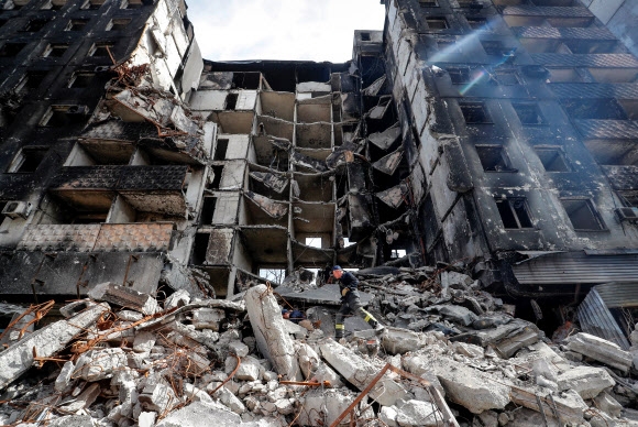 우크라이나 남동부 항구도시 마리우폴에서 러시아군의 침공으로 파괴된 건물 잔해를 작업자들이 치우고 있다. 2022.4.10 로이터 연합뉴스