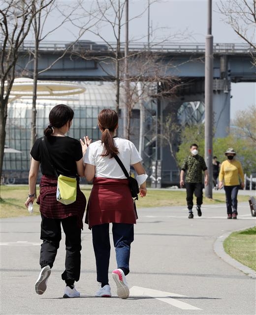 여름이 성큼 서울 최고 기온이 25도까지 오르는 등 초여름 날씨를 보인 11일 서울 반포 한강공원에서 겉옷을 벗은 반팔차림의 시민들이 산책하고 있다. 뉴스1