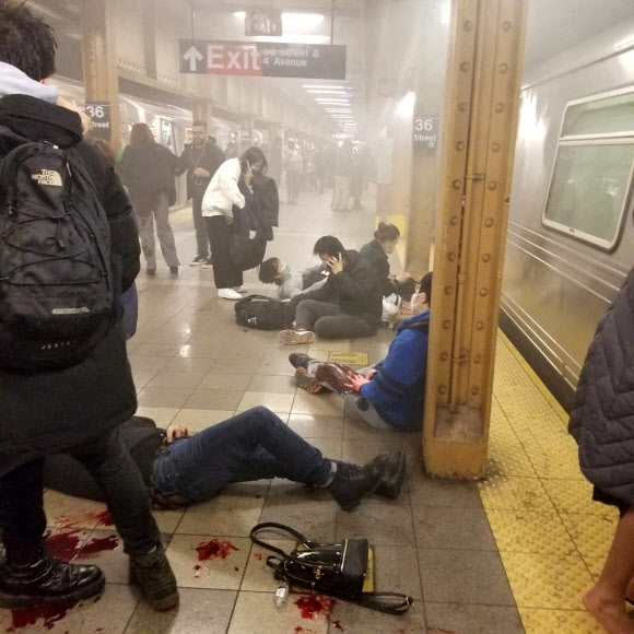 한 흑인 남성이 12일(현지시간) 오전 8시 30분쯤 미국 뉴욕 맨해튼 방면으로 향하는 지하철 객차 안에서 연막탄을 터뜨린 후 총기를 난사하는 사건이 발생했다. 다친 시민들이 브루클린 선셋파크의 36번가역 승강장에서 구조를 기다리고 있다. 뉴욕 로이터 연합뉴스