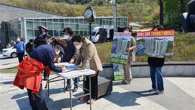 지난 15일 서울 노원구 불암산 철쭉동산에서 ‘불암산 자연경관 보존 비상대책위원회’가 주민들의 서명을 받고 있다.