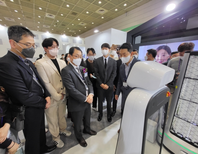 구현모(왼쪽에서 세번째) KT 대표가 20일 서울 강남 코엑스에서 열린 ‘2022 월드IT쇼’에서 LG전자의 클로이 로봇을 살펴보고 있다.