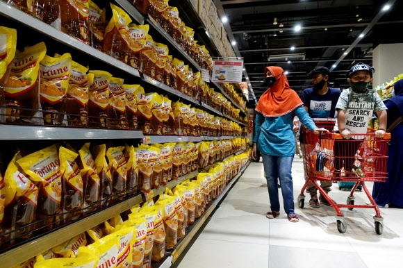 인도네시아 자카르타의 한 슈퍼마켓에서 사람들이 팜유로 만든 식용유를 사려고 보고 있다. 2022.3.27 로이터 연합뉴스