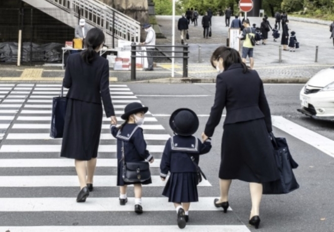 22일 일본 도쿄에서 아이들이 부모 손을 잡고 등교하고 있다. AFP 연합뉴스