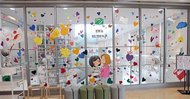 서울 동작구립 김영삼도서관 어린이자료실에 숭실대 시각디자인과 학생들이 진행한 ‘그림책 미술관 프로젝트-뽀뽀는 무슨 색일까’가 전시돼 있다. 아이들이 하트를 자유롭게 떼었다 붙였다 할 수 있도록 했다.  동작구 제공