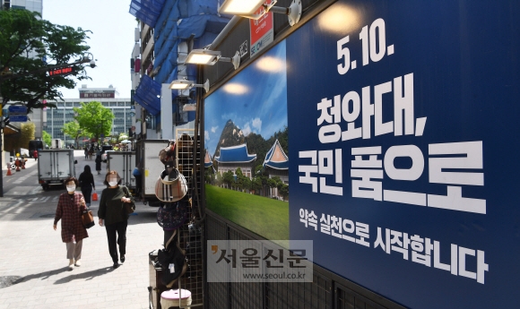 27일 오전 서울 명동거리의 한 상점 벽면에 청와대 개방 홍보 안내판이 걸려 있다. 2022.04.27 안주영 전문기자