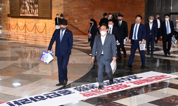 30일 서울 여의도 국회에서 열린 본회의에서 더불어민주당 의원들이 본회의장으로 입장하고 있다. 밑에 깔려 있는 현수막은 이 법안을 반대하는 내용의 국민의힘 현수막. 이날 국회는 검찰의 수사권과 기소권을 분리하는 내용의 검찰청법 개정안을 통과시켰다. 2022.04.30 오장환 기자