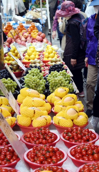 노점에 진열된 다양한 색깔의 과일들.