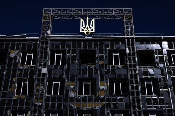 러시아의 우크라이나 침공 후 포격으로 파괴된 남동부 항구도시 마리우폴의 한 건물 꼭대기에 우크라이나 국장이 보인다. 2022.4.24 타스 연합뉴스