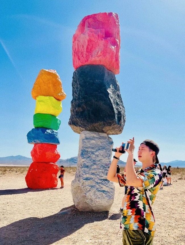 그룹 BTS(방탄소년단) 멤버 RM이 미국 라스베이거스 네바다 사막에 전시된 우고 론디노네의 작품 ‘세븐 매직 마운틴스’ 앞에서 인증사진을 찍고 있다. 인스타그램 캡쳐